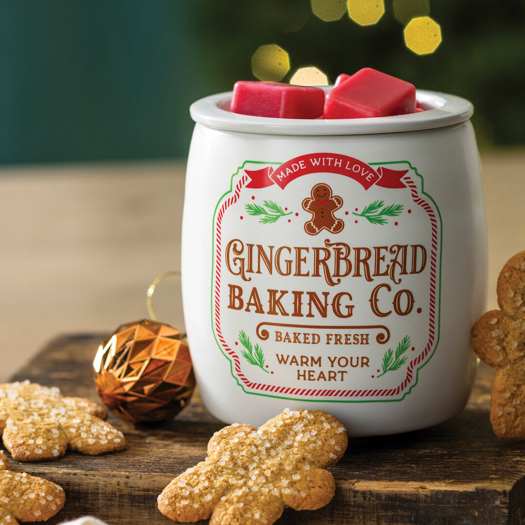 Gingerbread-Cookie-Duftlampe mit roten Wachswürfeln, dekoriert mit Lebkuchenfiguren und einer goldfarbenen Weihnachtskugel.